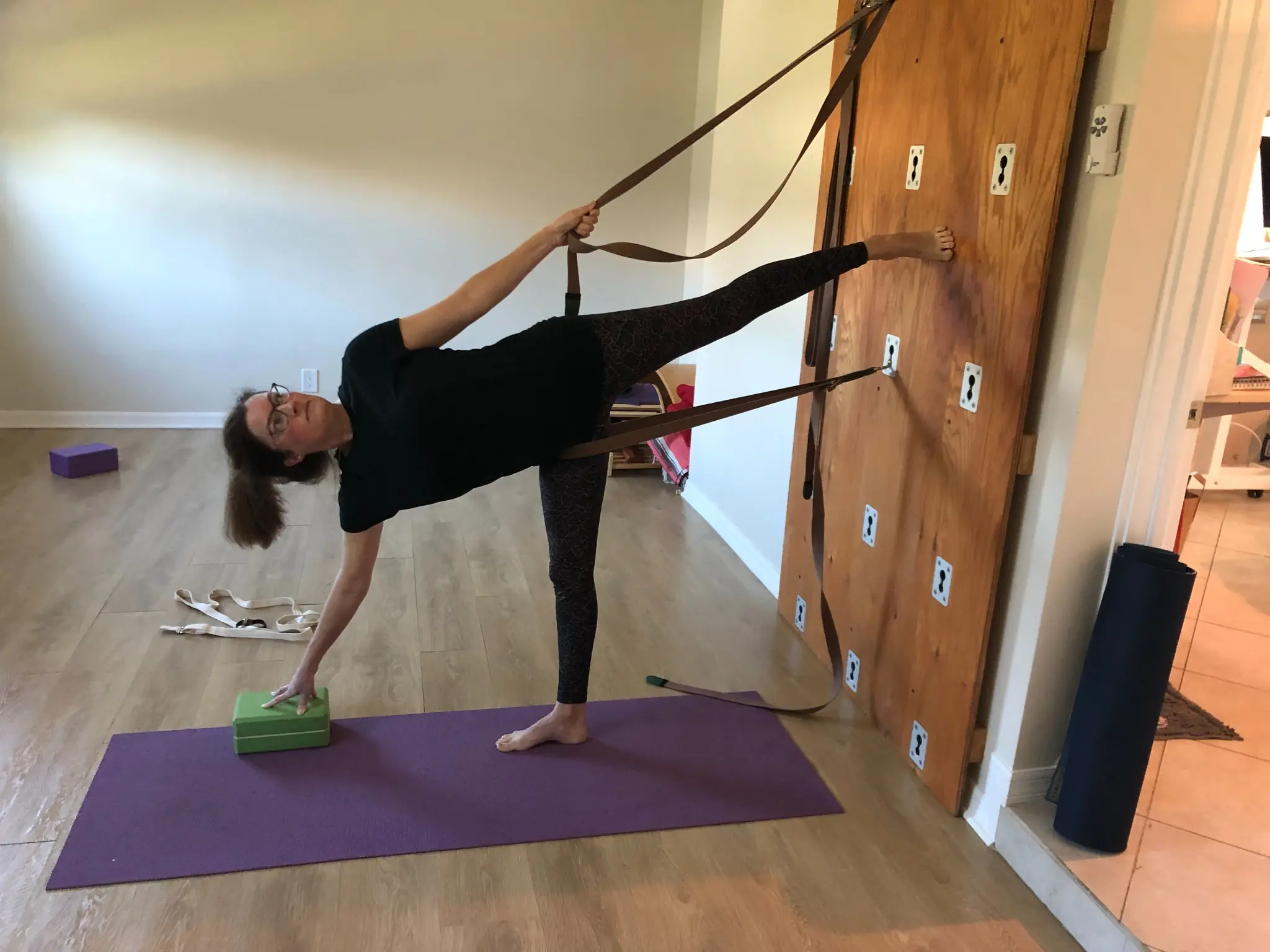 Half moon pose supported by straps on the Yoga Wall